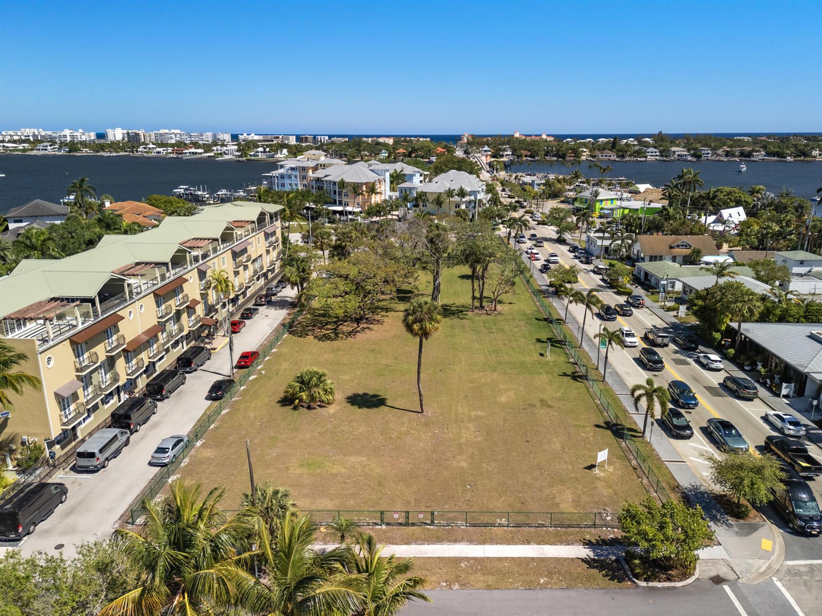 An aerial view shows a vacant grassy lot situated between a multi-story building and a road — 201 E Ocean Avenue, Lantana FL 33462, LANTANA, FL