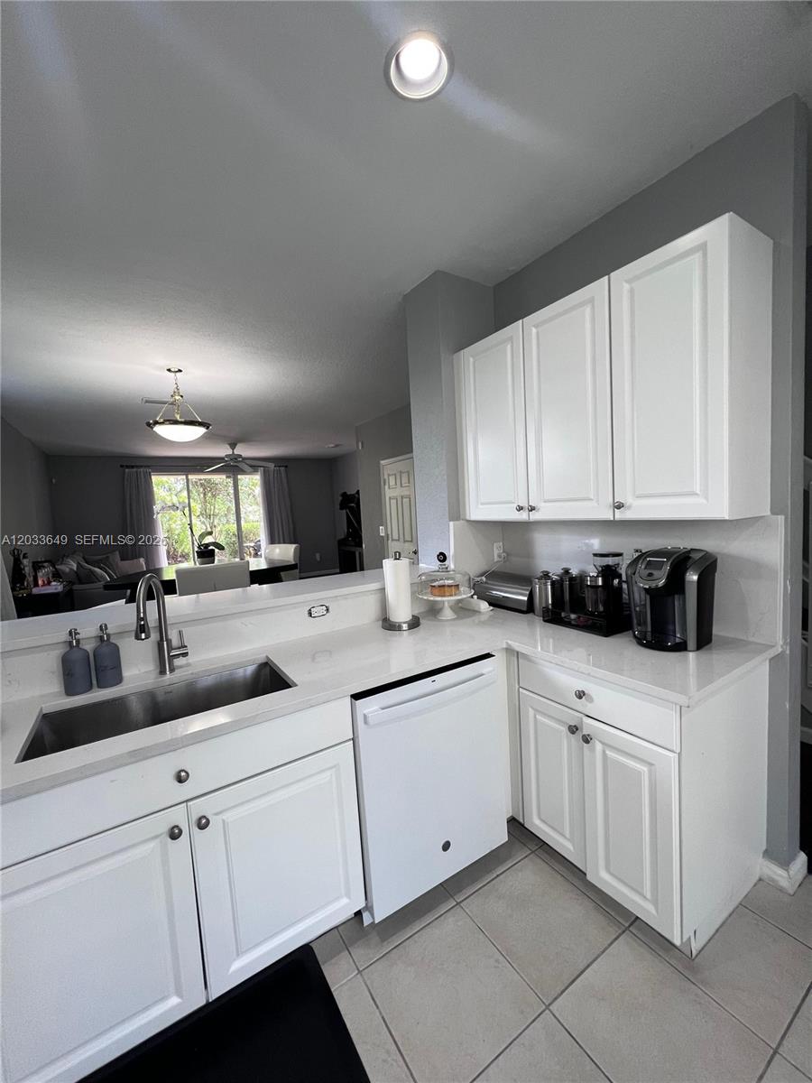 A kitchen features white cabinets, a stainless steel sink, and a dishwasher with white countertops — 681 NW 42nd Ave, Plantation FL 33317, PLANTATION, FL