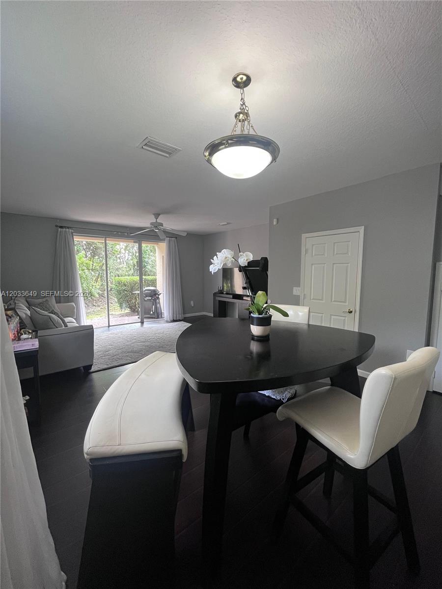 A dining area with a triangular table and bench seating opens to a living room — 681 NW 42nd Ave, Plantation FL 33317, PLANTATION, FL