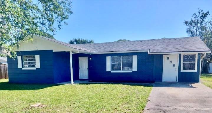 A single-story blue house with white trim and two white doors sits on a lawn — 2315 QUEEN PALM DRIVE, EDGEWATER, FL