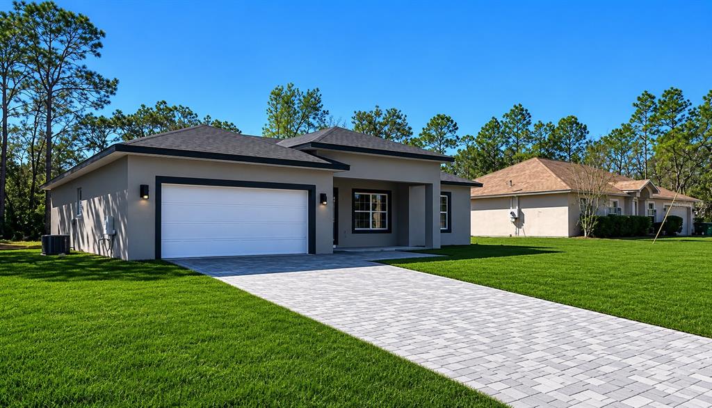 A single-story house with a white garage door, paved driveway, and a large front lawn — 3286 W CRANDON DRIVE, CITRUS SPRINGS, FL