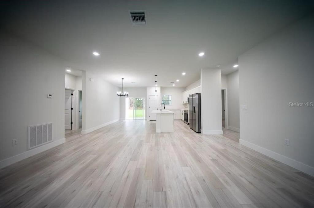 The exterior rear view of a single-story house features a covered patio and lawn — 3286 W CRANDON DRIVE, CITRUS SPRINGS, FL