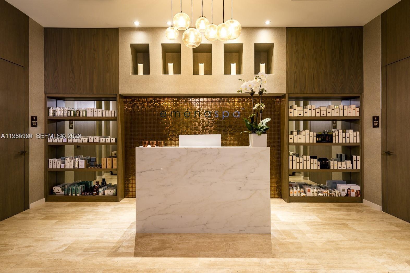 A spa reception area features a marble desk, gold mosaic wall, and built-in product shelves — 4111 S Ocean Dr # 1210, Hollywood FL 33019, HOLLYWOOD, FL