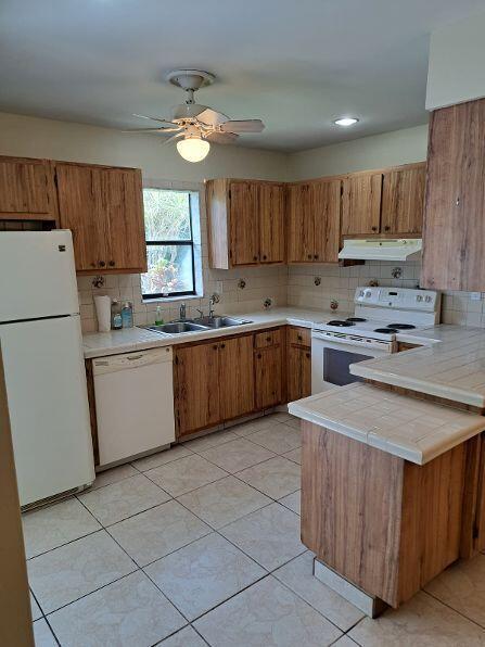A kitchen with wood cabinets, white appliances, tile flooring, and a ceiling fan — 9330 SW 61st Way # D, Boca Raton FL 33428, BOCA RATON, FL