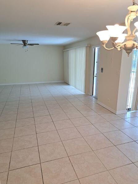 An open living area features light-colored tile flooring, a ceiling fan, and a chandelier — 9330 SW 61st Way # D, Boca Raton FL 33428, BOCA RATON, FL