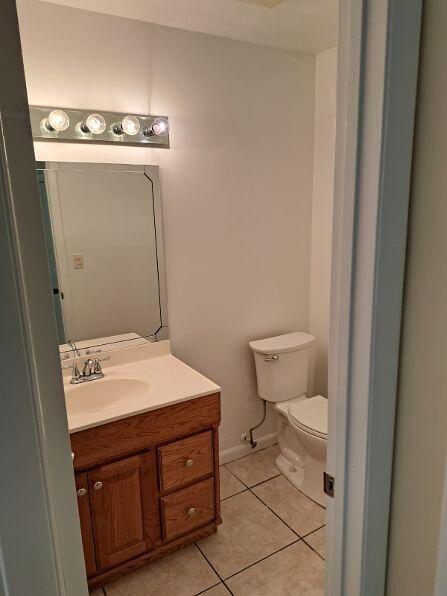 A small bathroom features a wooden vanity with a white sink, a mirror, and a toilet — 9330 SW 61st Way # D, Boca Raton FL 33428, BOCA RATON, FL