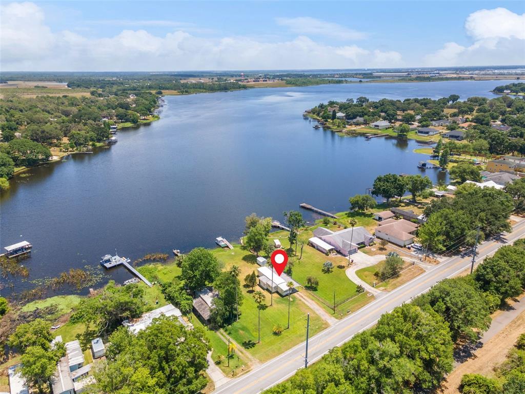 An aerial view shows a house with a red location pin beside a lake — 7558 BERKLEY ROAD, POLK CITY, FL