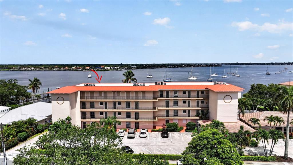An exterior view of a multi-story apartment building with a red roof near water — 624 SW ST LUCIE CRESCENT UNIT UN208, STUART, FL