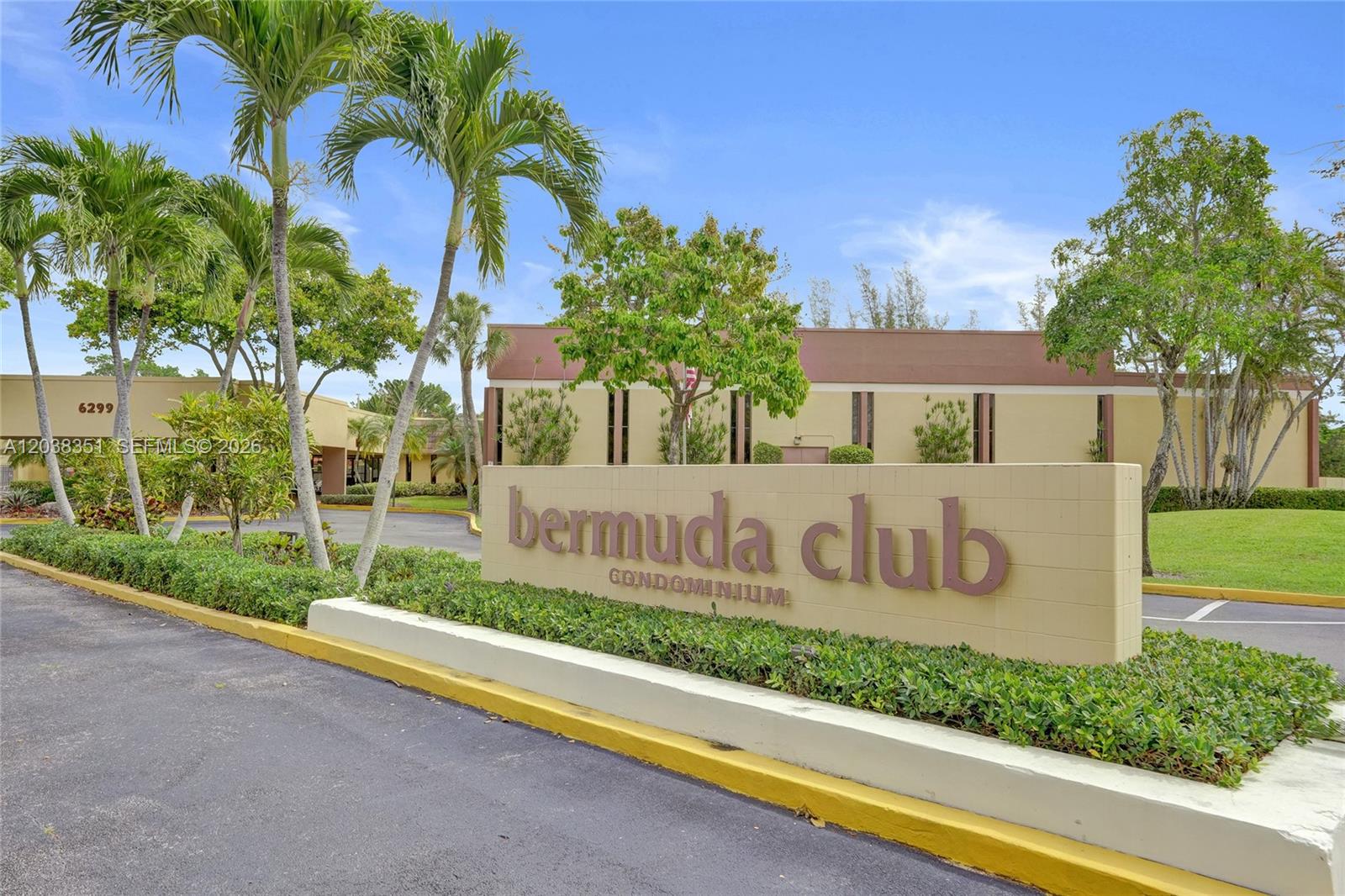 A sign for the Bermuda Club Condominium stands in front of a low-rise building with palm trees — 5961 NW 61st Ave # 310, Tamarac FL 33319, TAMARAC, FL