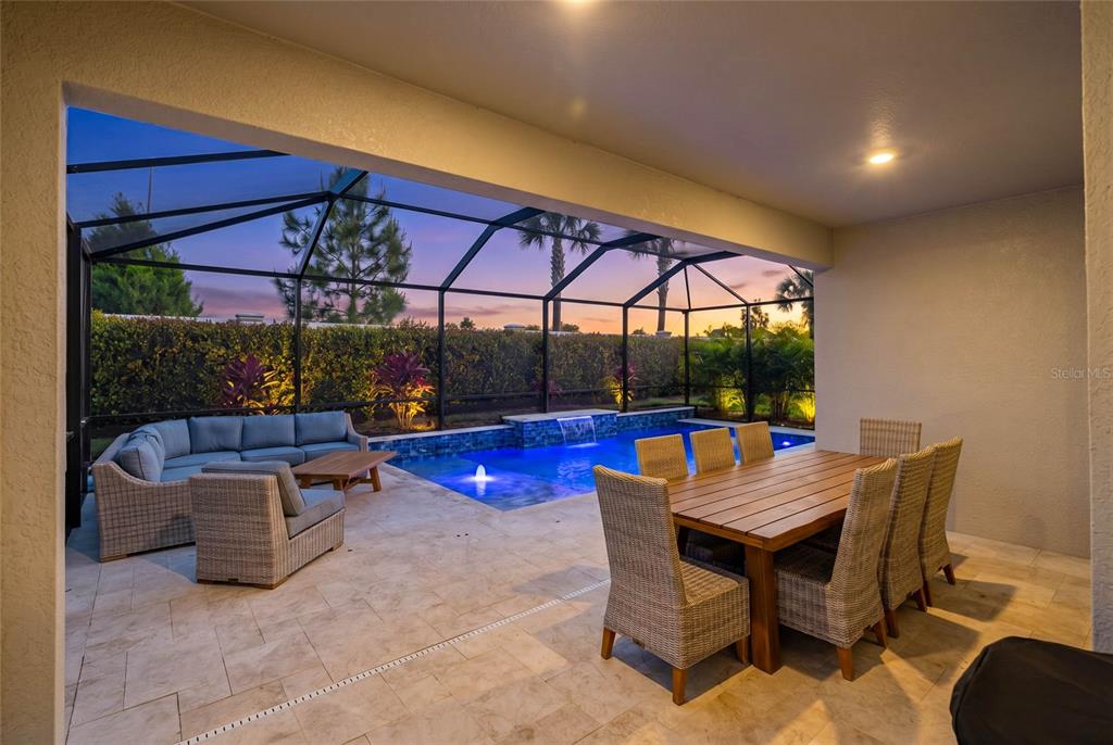 A living room with light wood floors, a sectional sofa, and a television console — 17526 SAVORY MIST CIRCLE, BRADENTON, FL