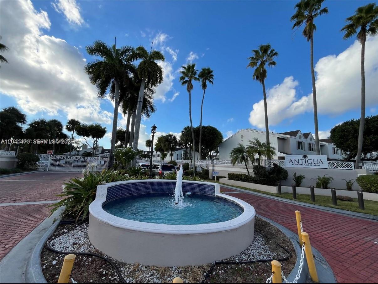 A fountain sits in front of the gated entrance to the Antigua residential community — 17515 NW 67th Ct # 22, Hialeah FL 33015, HIALEAH, FL