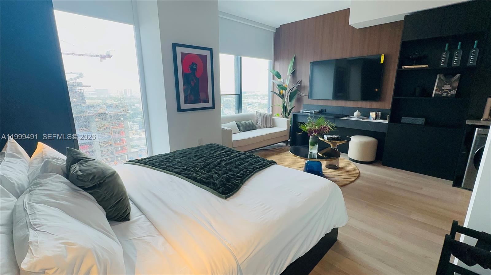 A modern kitchen features dark cabinetry, light countertops, and a built-in stainless steel washing machine — 20 NE 11 St, Miami FL 33132, MIAMI, FL