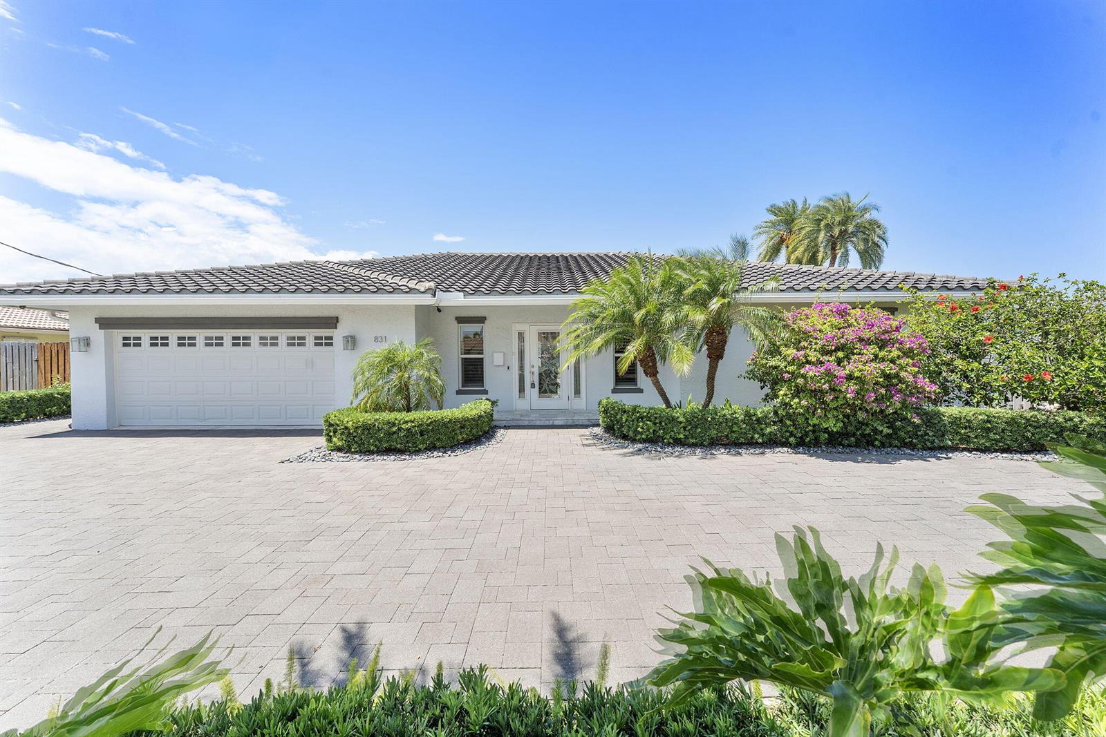 A single-story white house with a tiled roof, a paved driveway, and landscaped front gardens — 831 Dover Street, Boca Raton FL 33487, BOCA RATON, FL