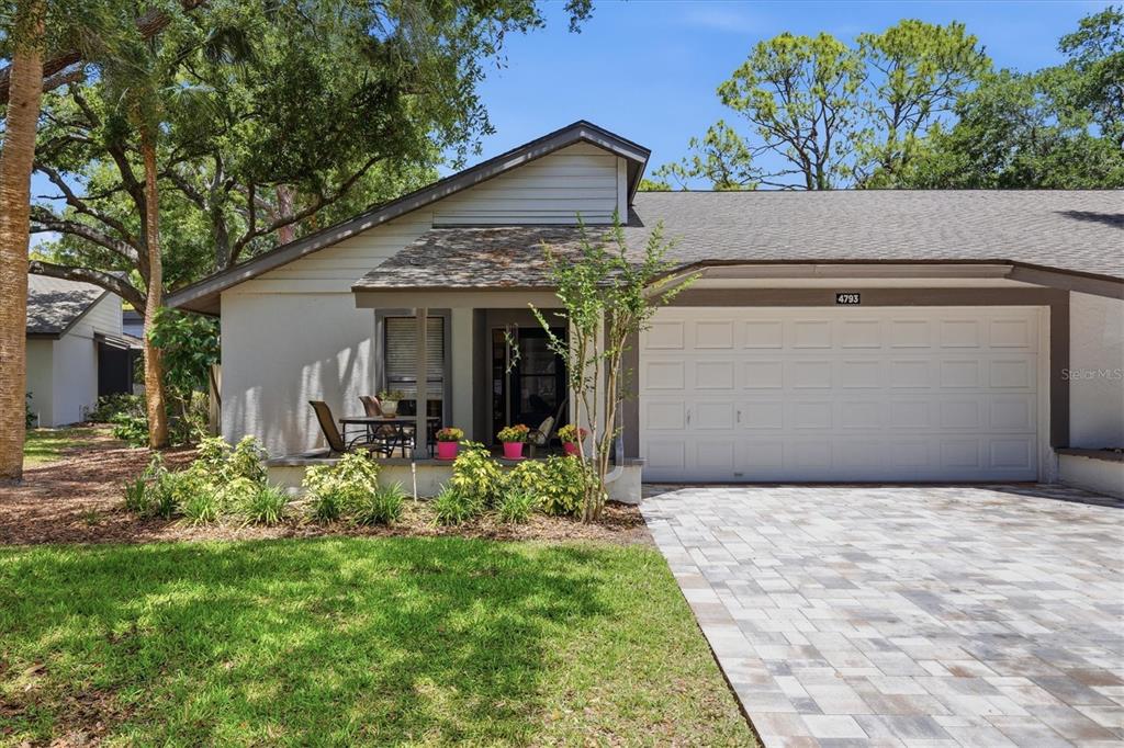 A single-story house with a paved driveway, a small front porch, and a white garage door — 4793 OAK FOREST DRIVE W UNIT 46, SARASOTA, FL