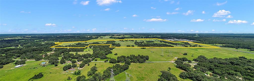An aerial view of a large, grassy rural property outlined in yellow — 412 E STATE ROAD 44, WILDWOOD, FL