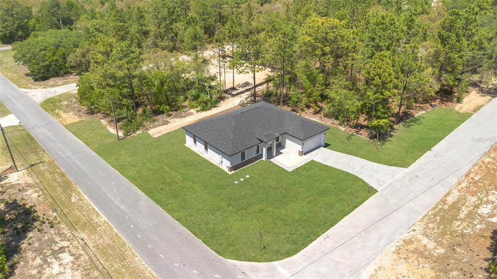An aerial view shows a single-story house with a dark roof on a corner lot — 8812 N LANSEN WAY, CITRUS SPRINGS, FL
