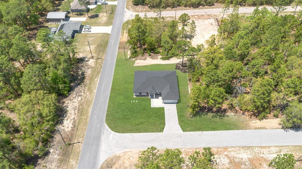 An aerial view shows a single-story house with a dark roof on a corner lot — 8812 N LANSEN WAY, CITRUS SPRINGS, FL
