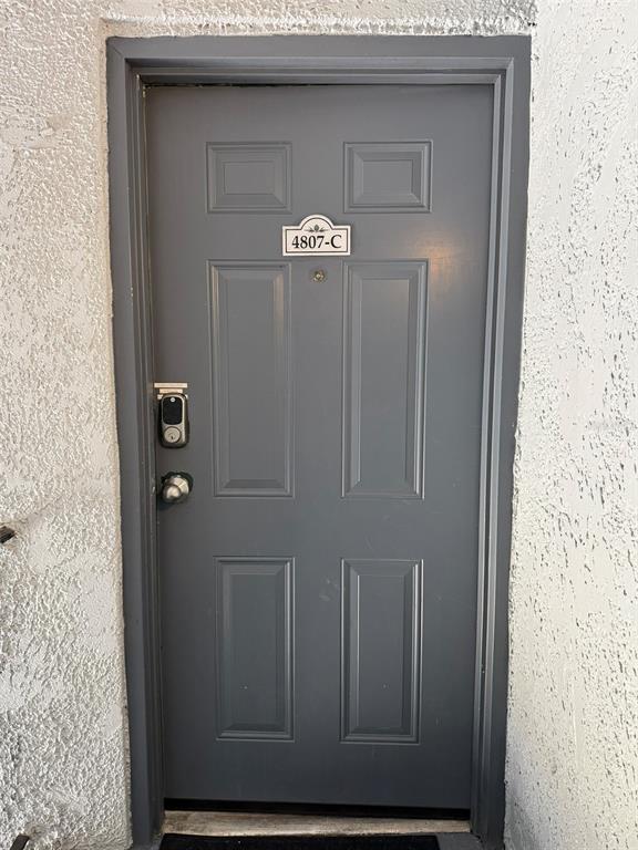 A gray four-panel door with a digital lock and a unit number sign — 4807 S TEXAS AVENUE UNIT 4807C, ORLANDO, FL