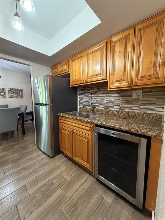 A kitchen features wood cabinets, granite countertops, a stainless steel refrigerator, and a wine cooler — 4807 S TEXAS AVENUE UNIT 4807C, ORLANDO, FL