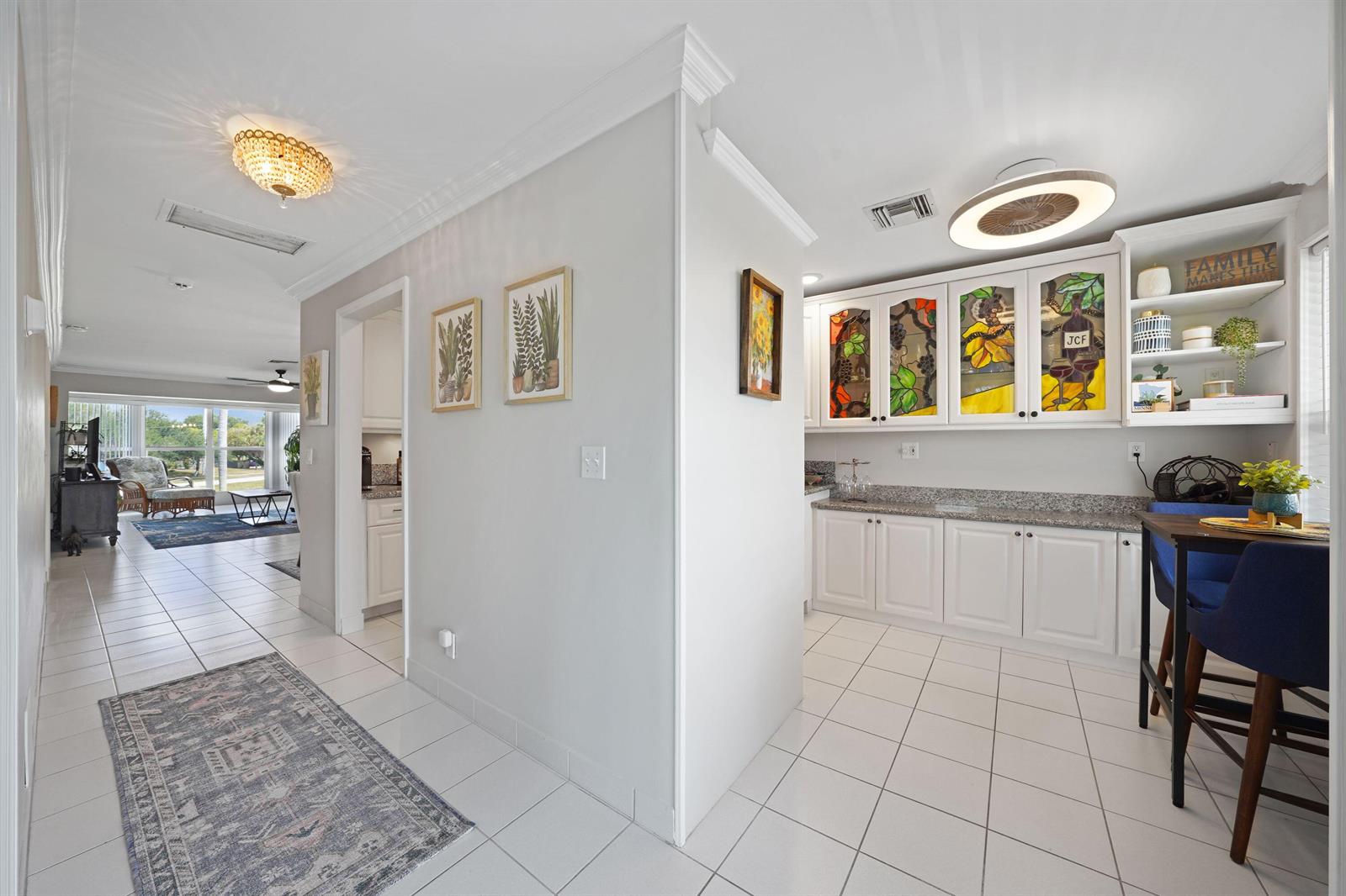 A bright kitchen area features white cabinets with stained glass inserts and tiled flooring — 2835 SW 13th Street # 201, Delray Beach FL 33445, DELRAY BEACH, FL