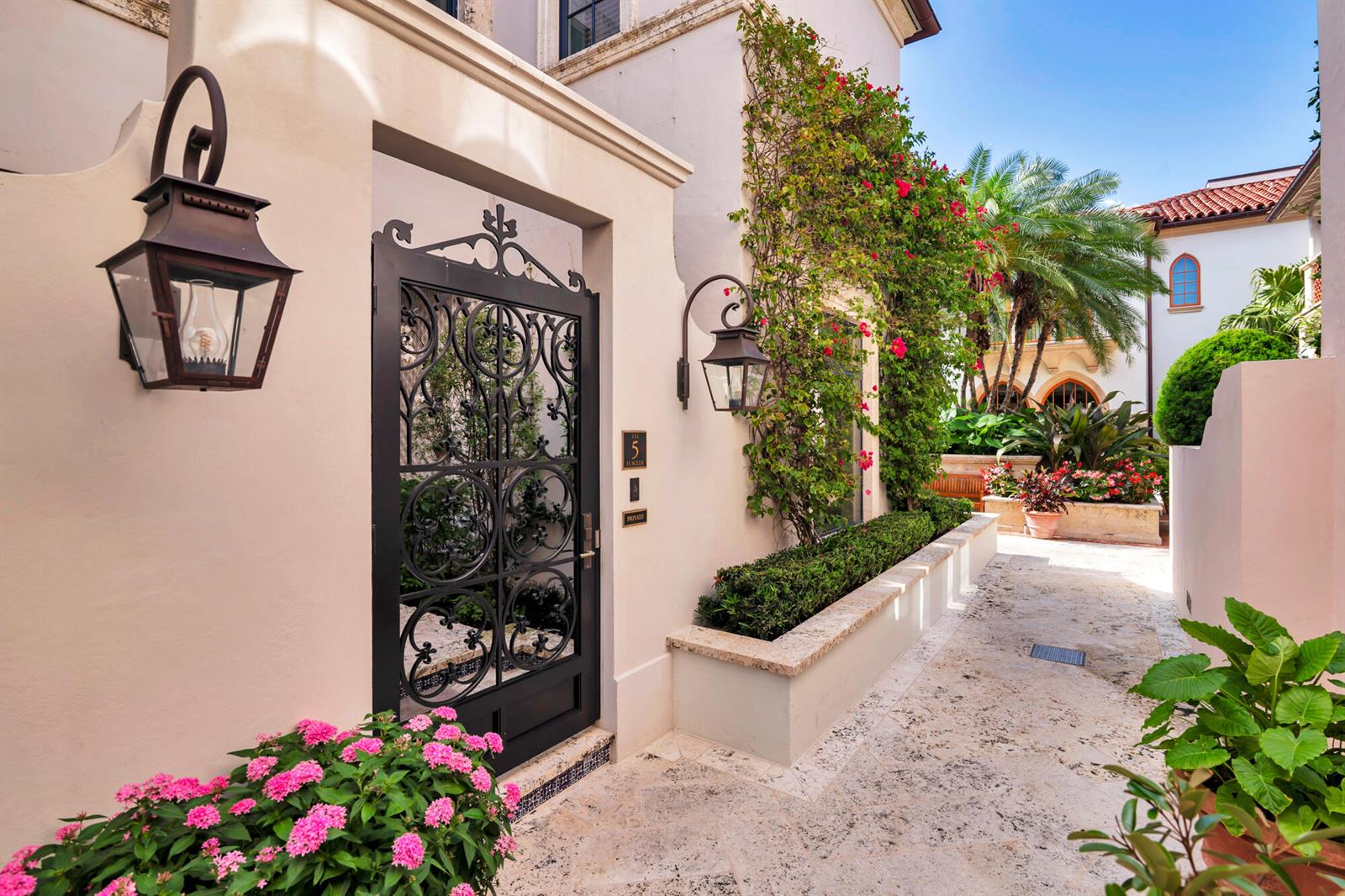 A wrought iron gate leads to a stone walkway beside a stucco wall with climbing bougainvillea — 5 Via Flagler, Palm Beach FL 33480, PALM BEACH, FL