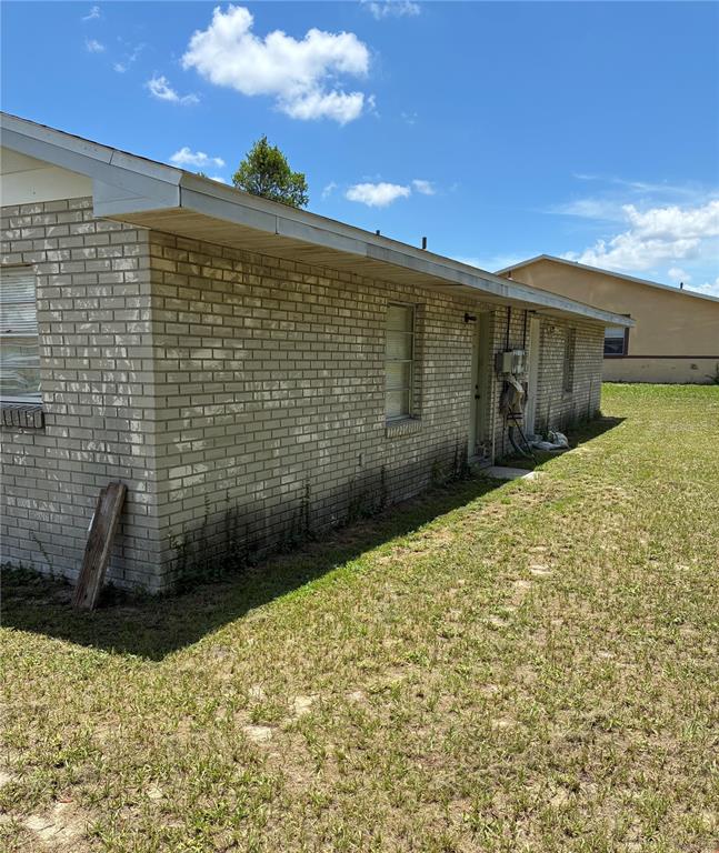 An exterior view of a single-story brick house with a grassy yard — 845 S CHAR MIL AVENUE, LAKE ALFRED, FL