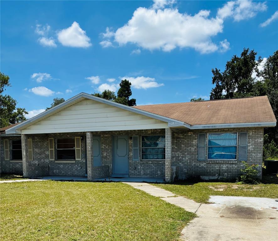 A single-story brick house with a covered front porch and a light-colored gable roof — 845 S CHAR MIL AVENUE, LAKE ALFRED, FL