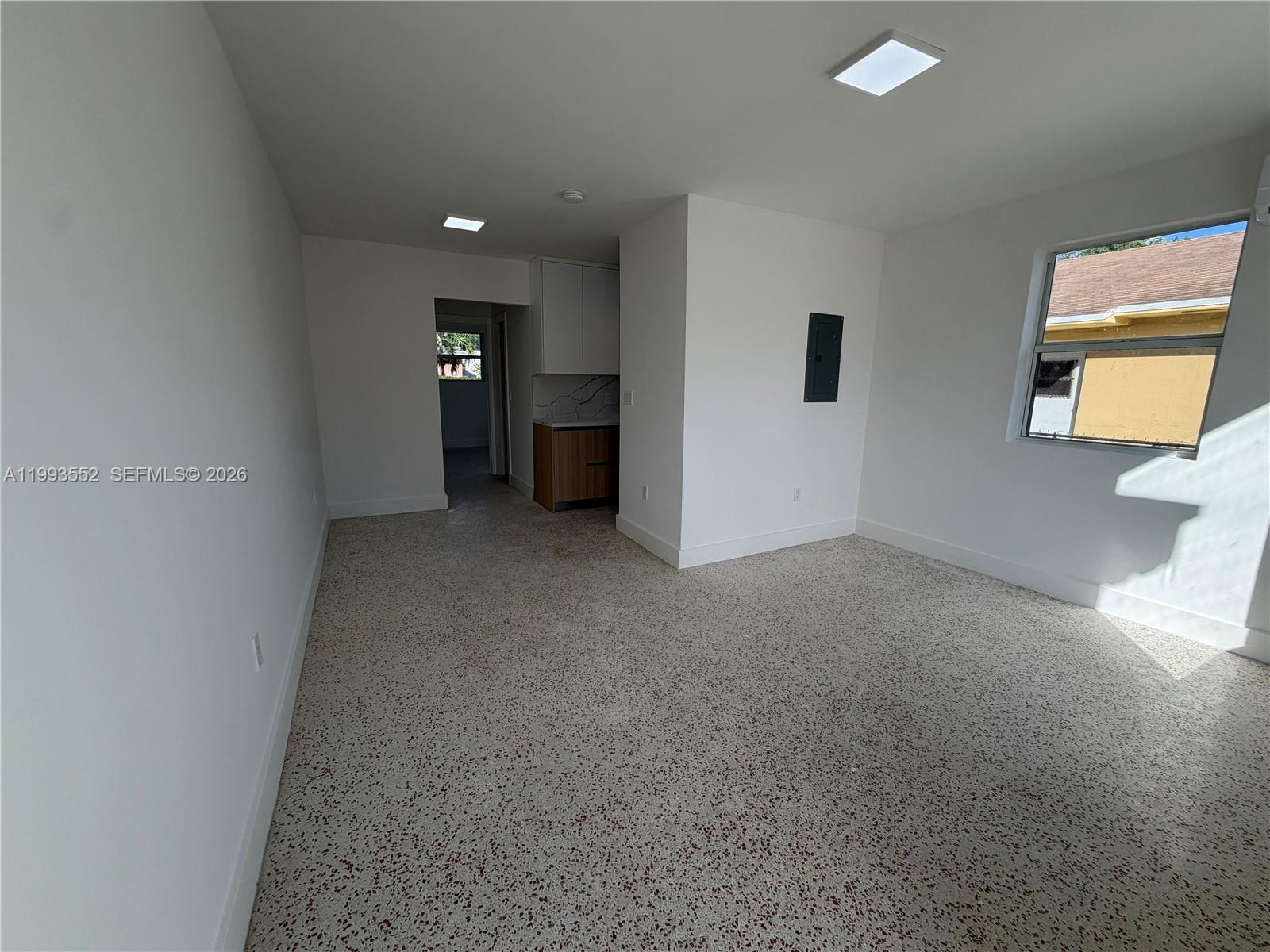 This room features white walls, a terrazzo floor, recessed lighting, and a small kitchenette area — 2784 SW 31st Pl, Miami FL 33133, MIAMI, FL
