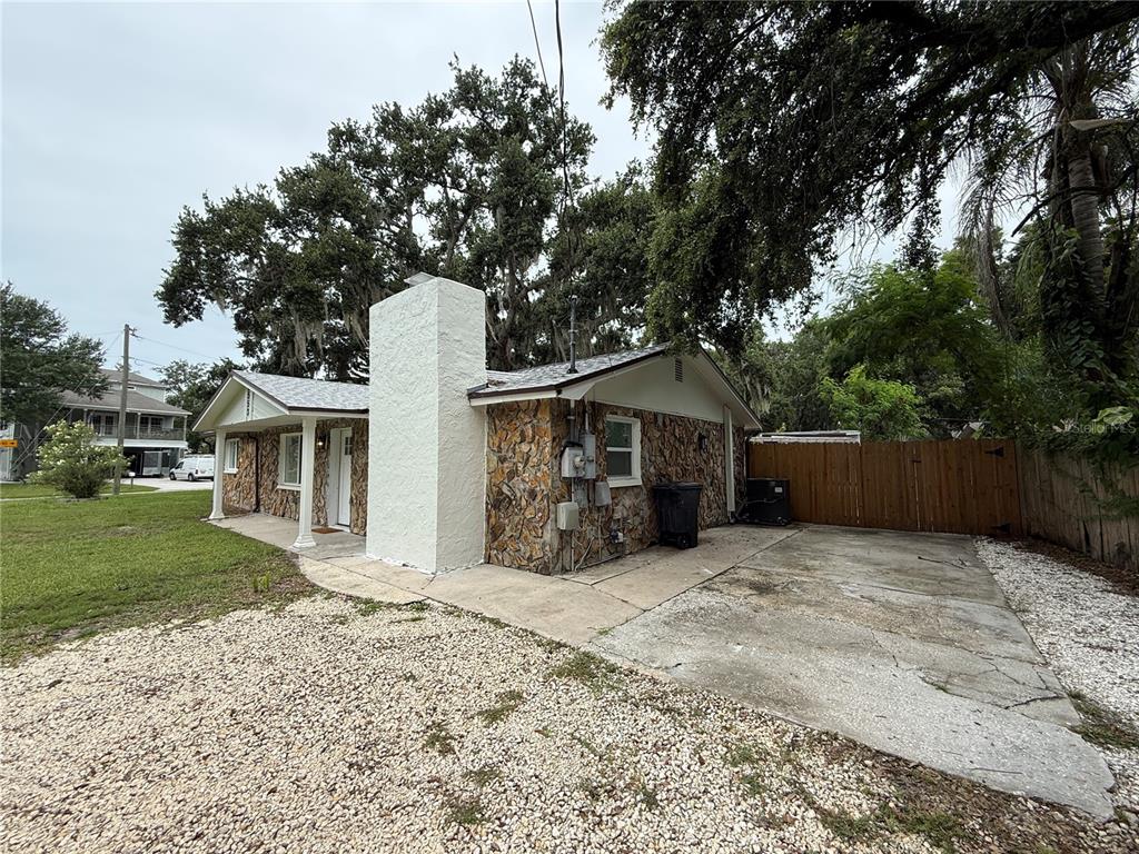 A single-story house with a stone facade, a white chimney, and a concrete driveway — 4553 EDITH STREET, NEW PORT RICHEY, FL