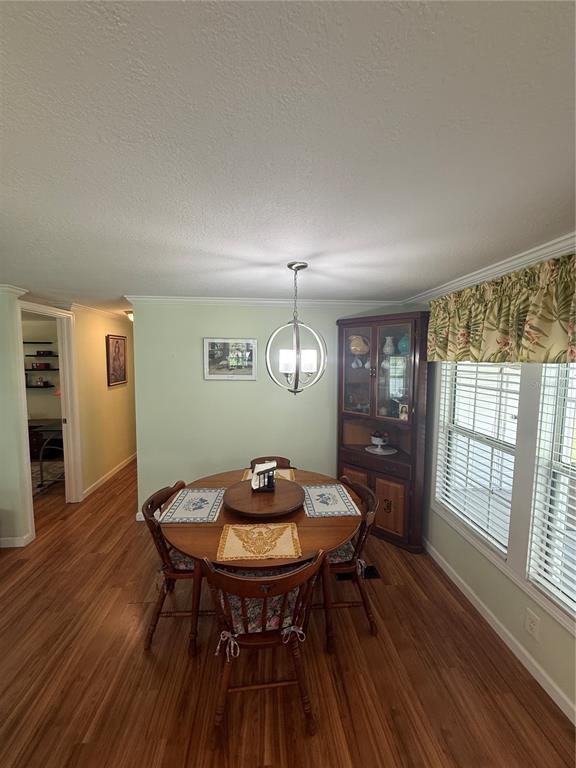 A dining room features a round wooden table, four chairs, a corner hutch, and light-green walls — 6100 62ND AVENUE N UNIT 71, PINELLAS PARK, FL