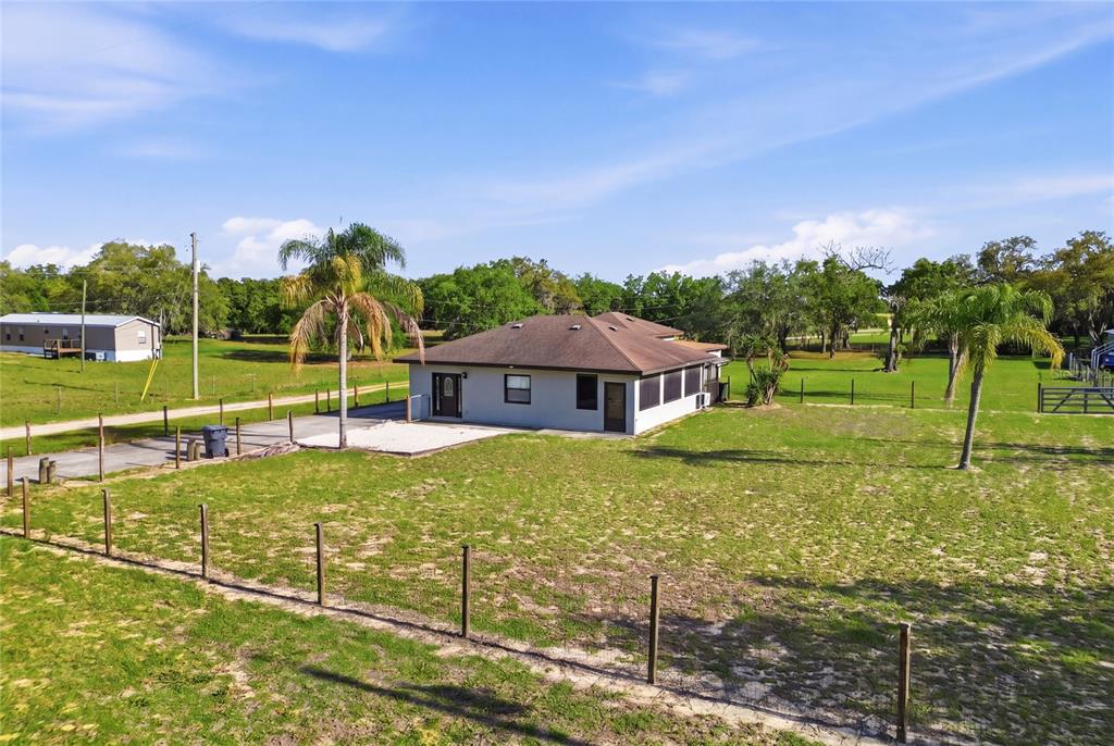 An exterior view of a single-story house with a brown roof and palm trees — 29 COYER RD UNIT 2, HAINES CITY, FL