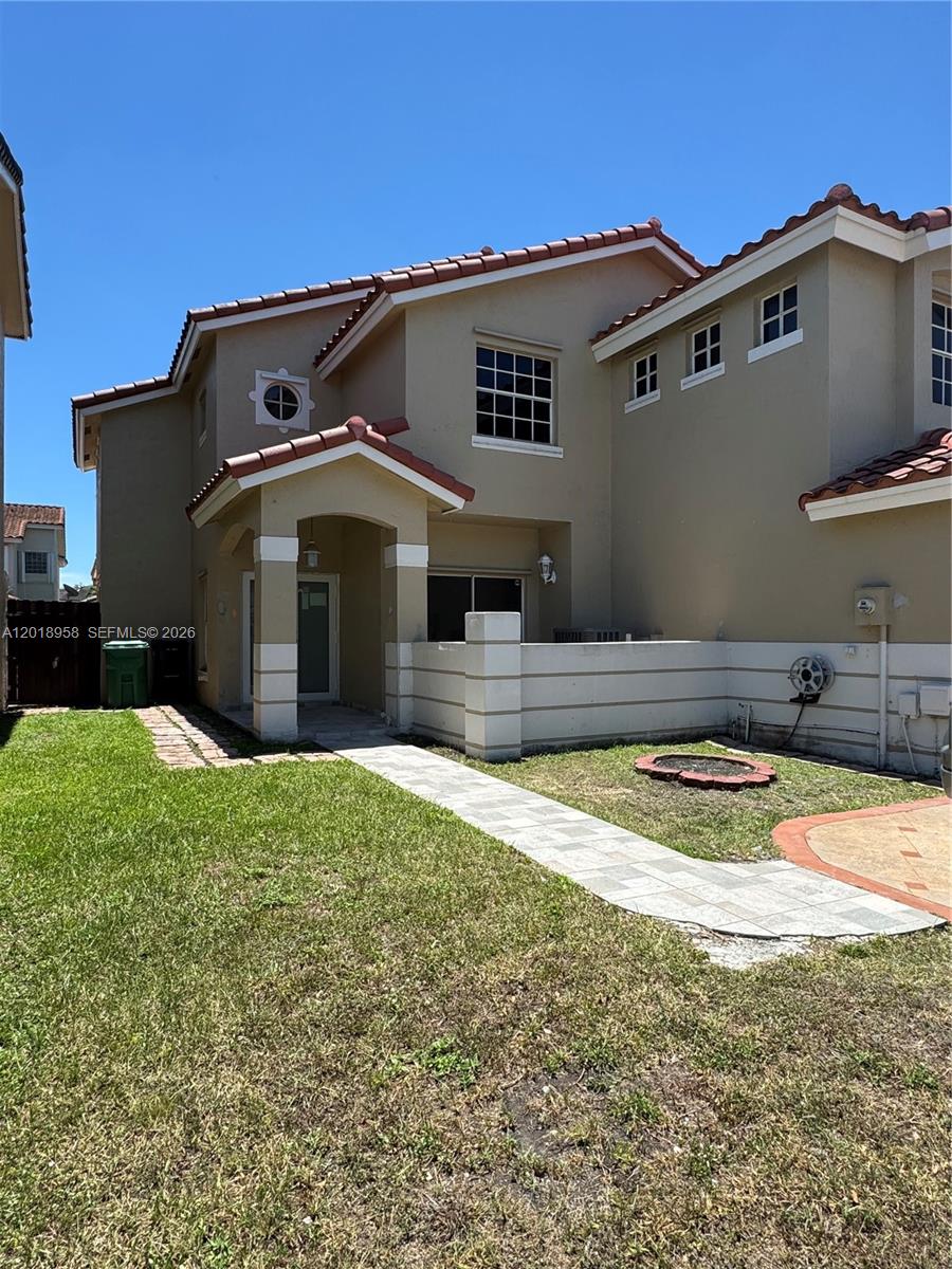 A two-story tan stucco house features a tiled roof, a covered entryway, and a walkway — 15428 SW 50th Ter # 0, Miami FL 33185, MIAMI, FL