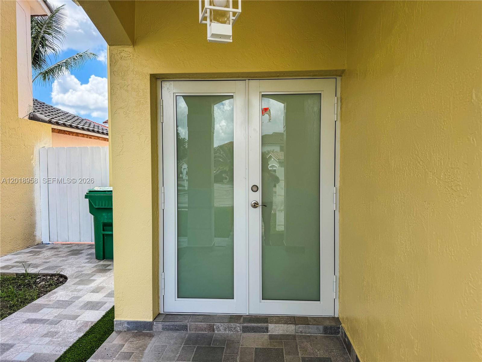 A set of white double doors with frosted glass panels sits under a yellow overhang — 15428 SW 50th Ter # 0, Miami FL 33185, MIAMI, FL