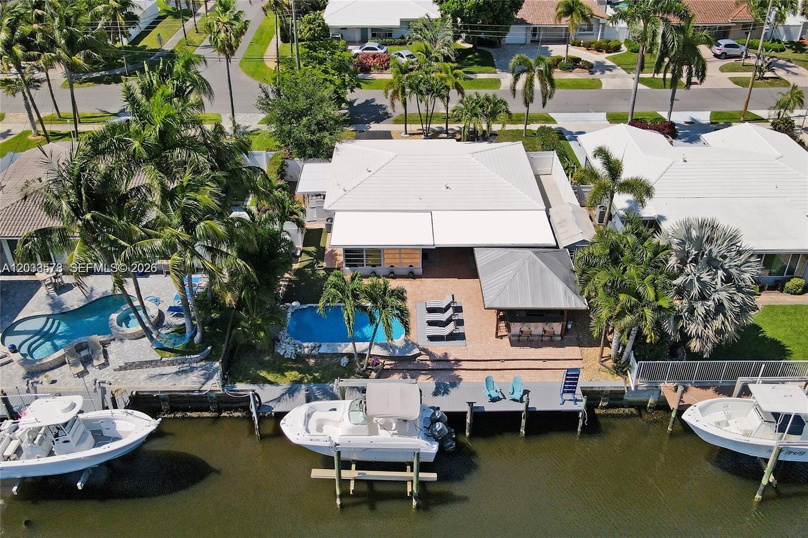 An aerial view shows a waterfront house with a pool, patio, and three docked boats — 200 SE 3rd St, Pompano Beach FL 33060, POMPANO BEACH, FL