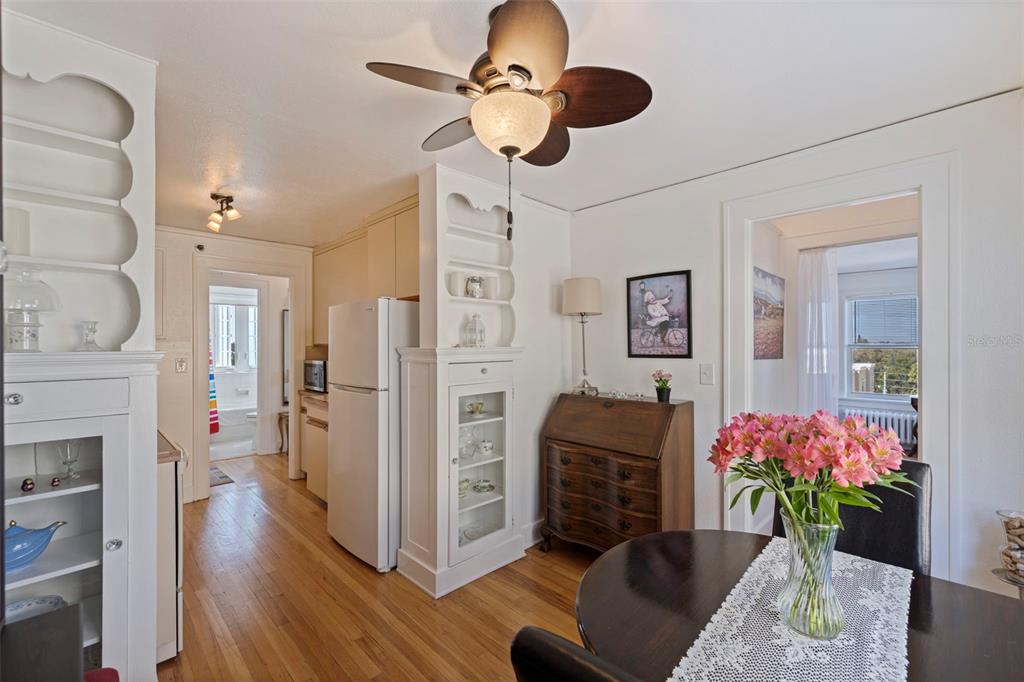 A dining area with a wooden table, built-in shelving, and a view into the kitchen — 130 4TH AVENUE N UNIT 602, ST PETERSBURG, FL