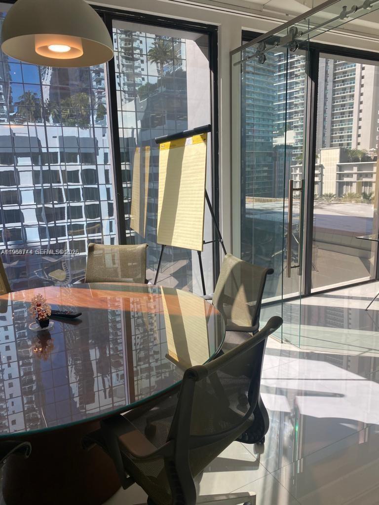 A modern conference room features a glass-topped table, office chairs, and floor-to-ceiling windows — 1110 Brickell Ave # 804, Miami FL 33131, MIAMI, FL