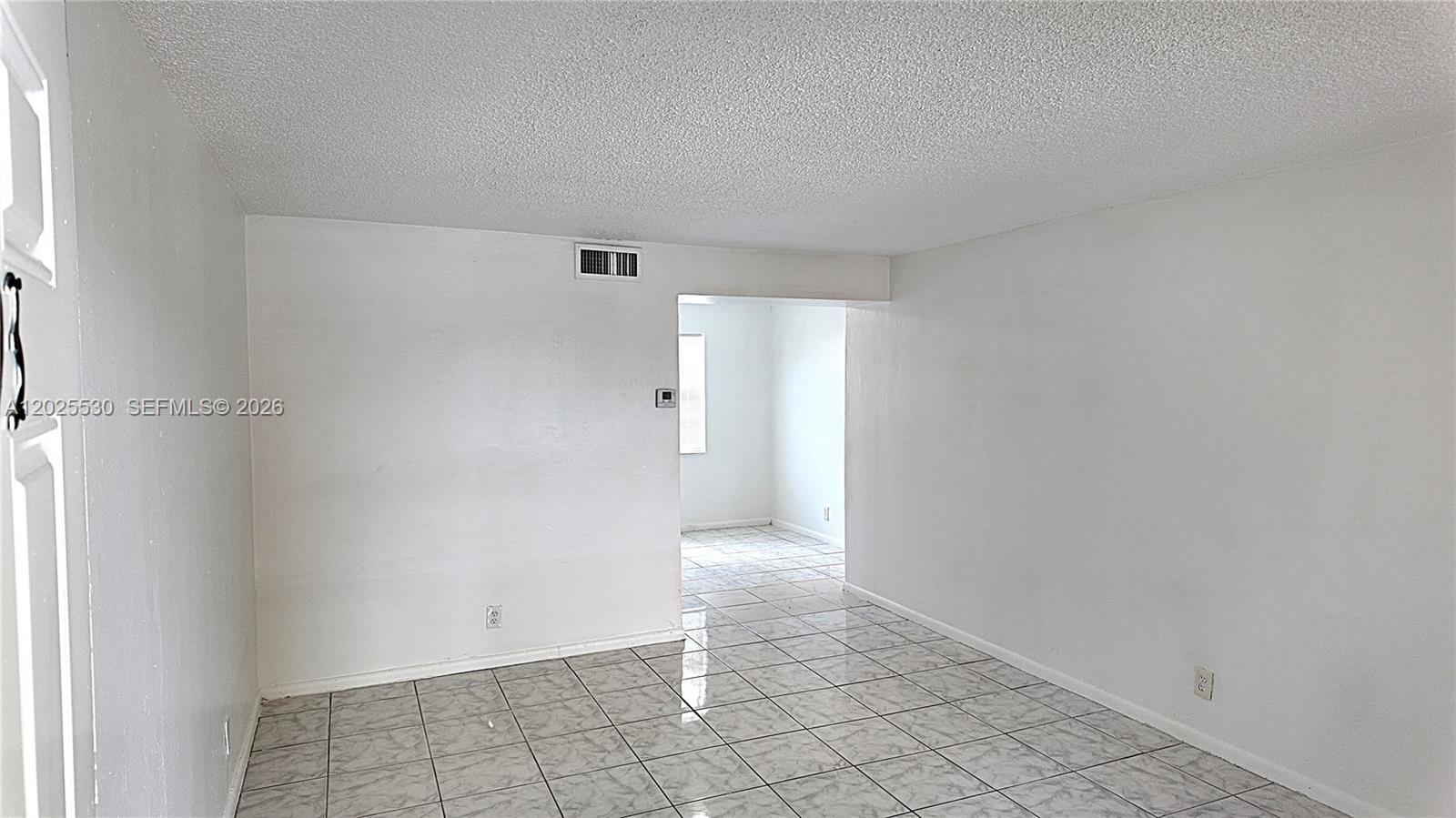 An empty room with white walls, a textured ceiling, and light-colored tiled flooring — 31 SE 2nd Ave # 203, Hallandale Beach FL 33009, HALLANDALE BEACH, FL