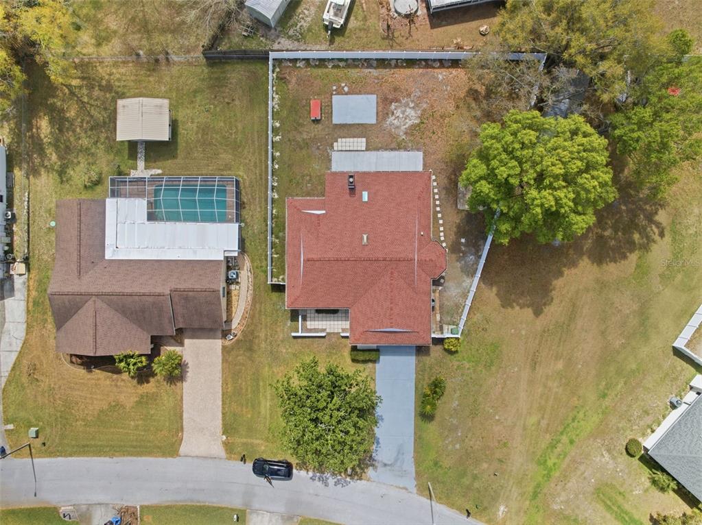 An aerial view shows two adjacent residential properties with driveways, a swimming pool, and trees — 22368 SOUTHSHORE DRIVE, LAND O LAKES, FL