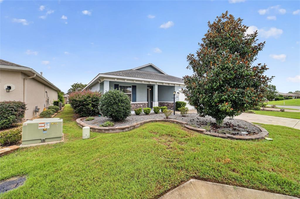 A single-story house with a front porch, stone accents, and a large tree in front — 9269 SW 97TH CIRCLE, OCALA, FL