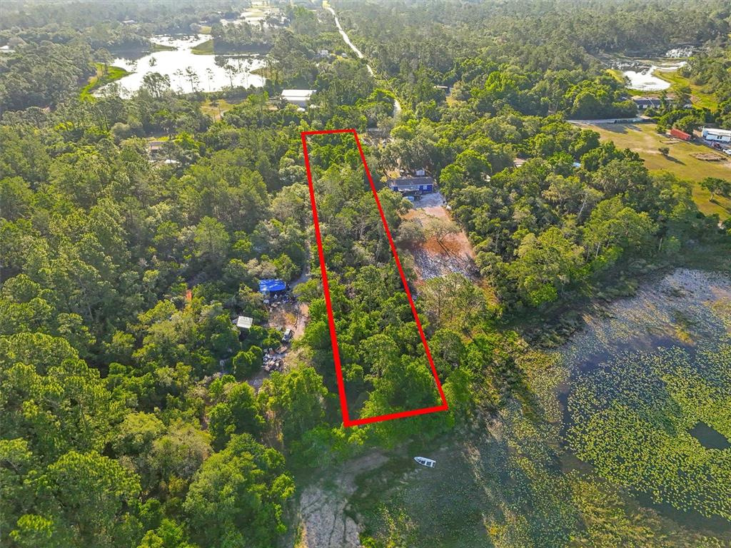 An aerial view shows a rectangular property lot outlined in red bordering a lake — JEWELL DRIVE, DELAND, FL