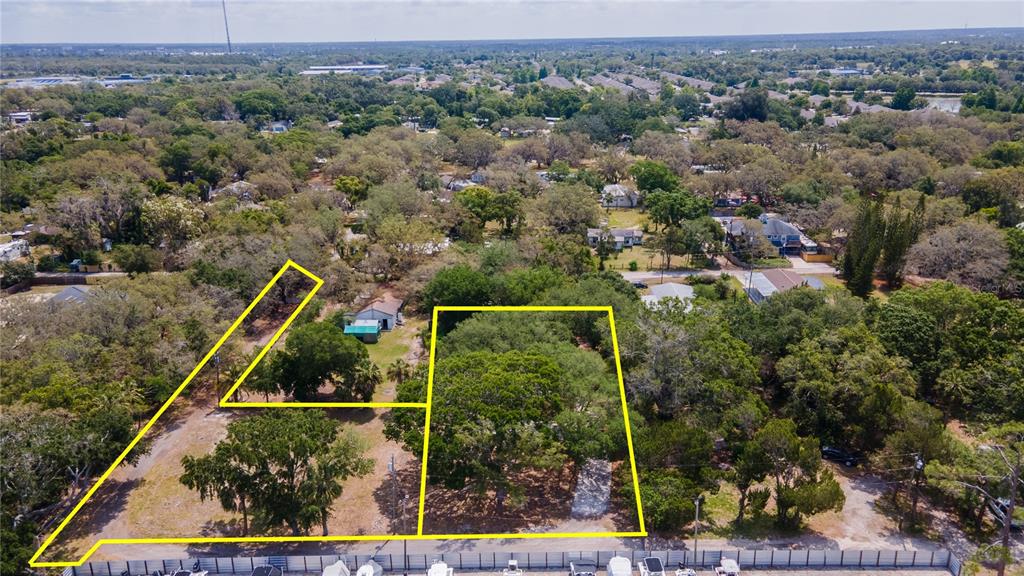 An aerial view shows two adjacent, tree-covered vacant lots outlined in yellow — 1810, 1814 CEMETERY ROAD, HOLIDAY, FL