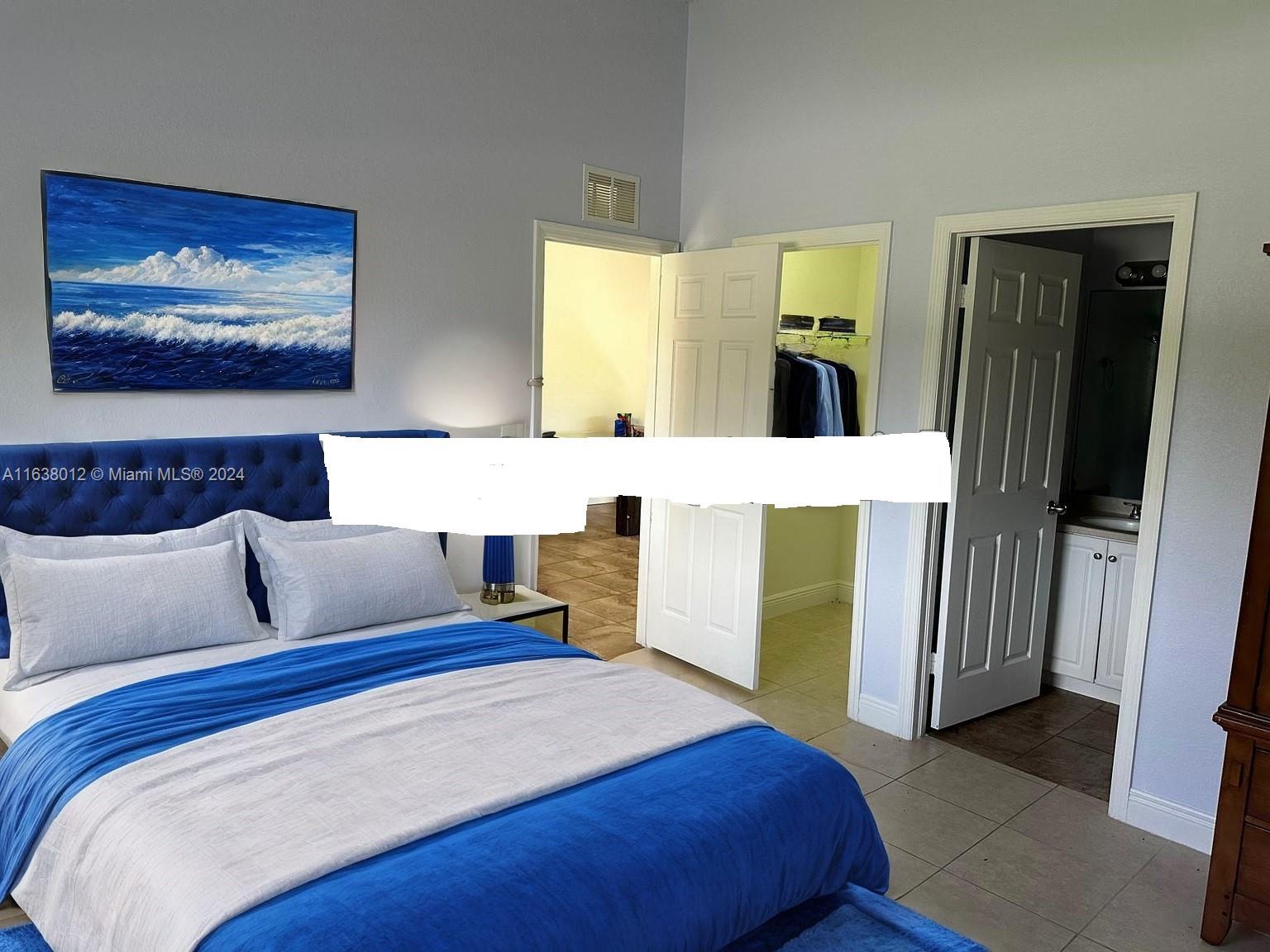 A bedroom features a blue upholstered bed, a walk-in closet, and an attached bathroom — 466 rewing st, Lehigh Acres FL 33974, LEHIGH ACRES, FL