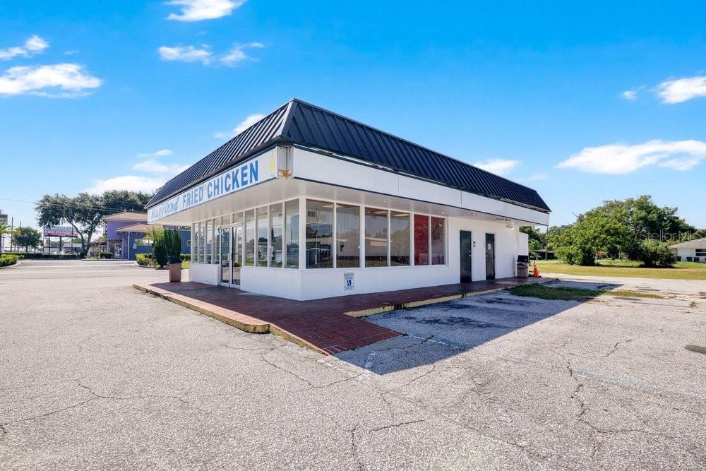 A standalone commercial building with a flat roof and large windows sits on a lot — 9710 E COLONIAL DRIVE, ORLANDO, FL
