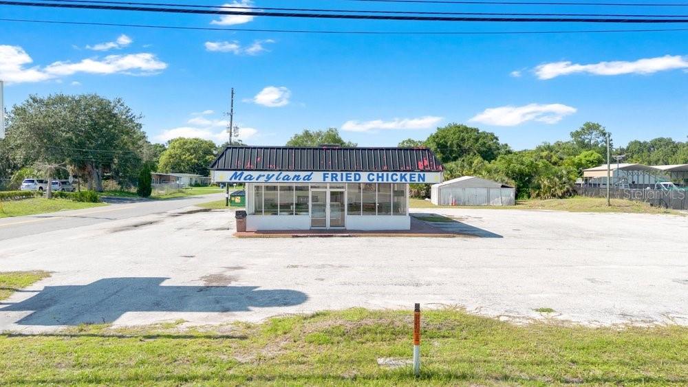 A standalone Maryland Fried Chicken restaurant building sits in the middle of a large parking lot — 9710 E COLONIAL DRIVE, ORLANDO, FL