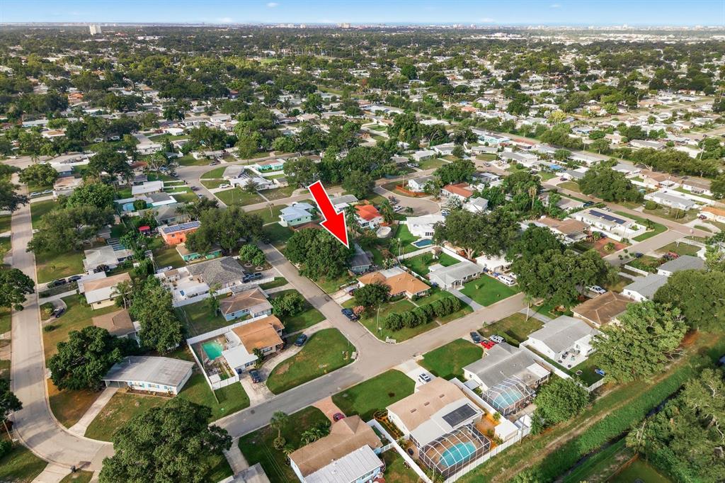 An aerial view shows a residential neighborhood with a red arrow pointing to a house — 3280 56TH WAY N, ST PETERSBURG, FL