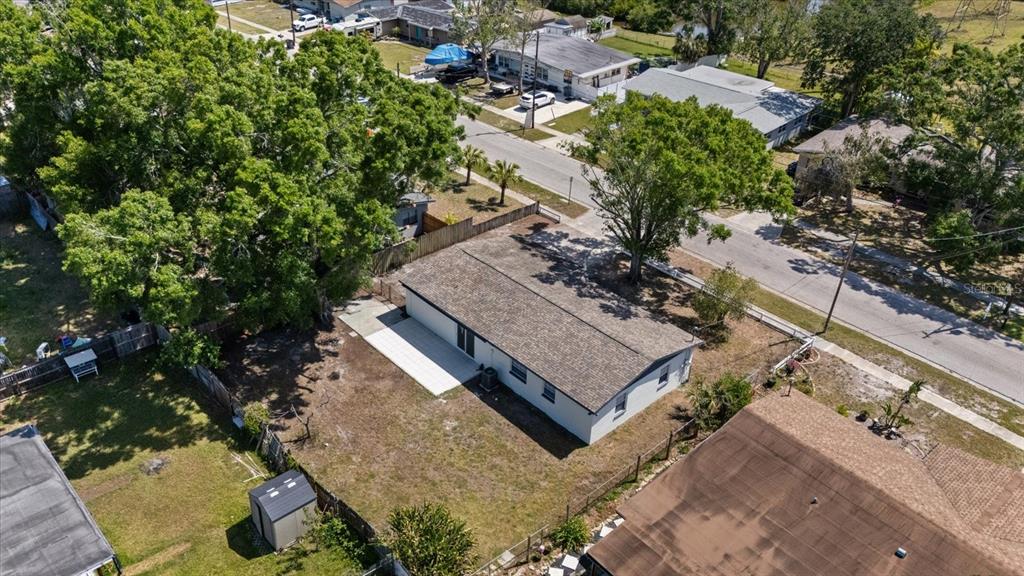 An aerial view shows a single-story house with a shingled roof and a backyard patio — 324 COUNTRY CLUB DRIVE, OLDSMAR, FL