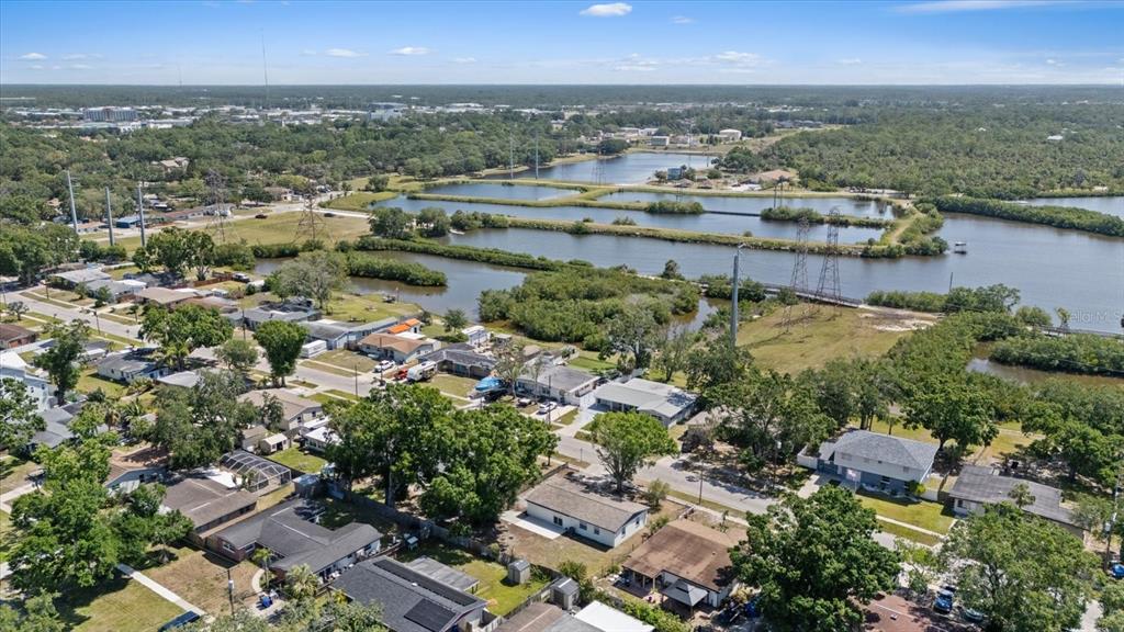 An aerial view shows a residential neighborhood bordering a series of interconnected ponds and wetlands — 324 COUNTRY CLUB DRIVE, OLDSMAR, FL