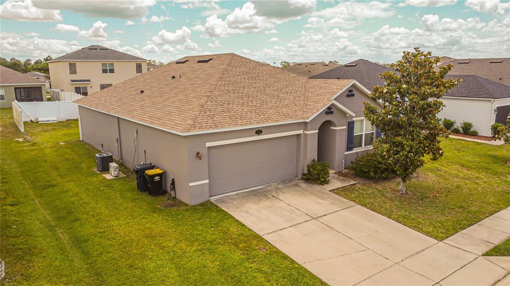 An aerial view shows a single-story house with a tan roof, gray exterior, and driveway — 1742 VAN GOGH DRIVE, AUBURNDALE, FL