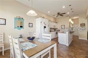 A dining area with a wooden table and white chairs sits adjacent to a kitchen — 17951 SE 115TH CIRCLE, SUMMERFIELD, FL