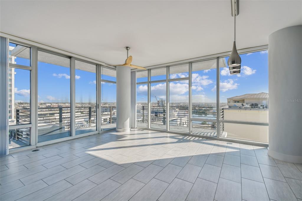 An empty room with light tile flooring, floor-to-ceiling windows, and a ceiling fan — 1208 E KENNEDY BOULEVARD UNIT 1115, TAMPA, FL